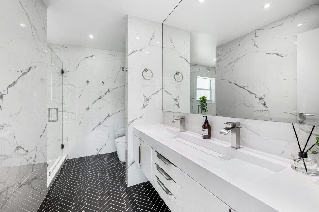 Explore the elegance of a modern bathroom featuring marble walls and sleek fixtures.